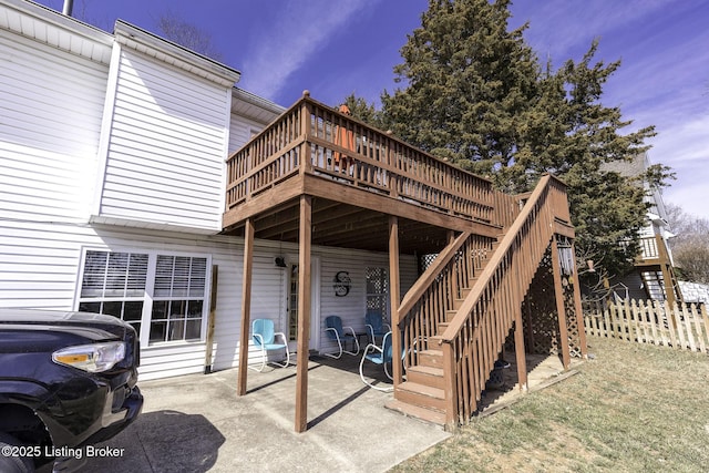 entrance to property with a wooden deck, a patio, and fence