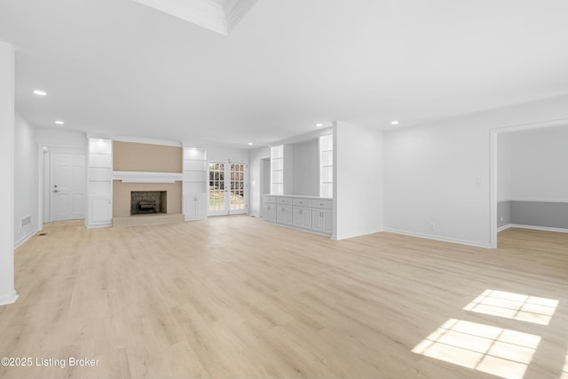 unfurnished living room with recessed lighting, a brick fireplace, baseboards, and light wood-style floors