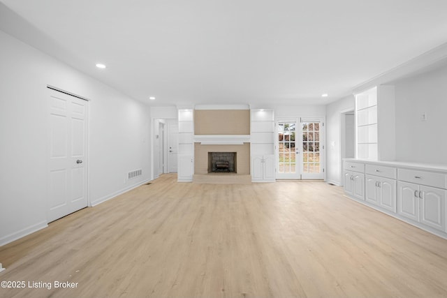 unfurnished living room featuring visible vents, a brick fireplace, baseboards, recessed lighting, and light wood-style floors