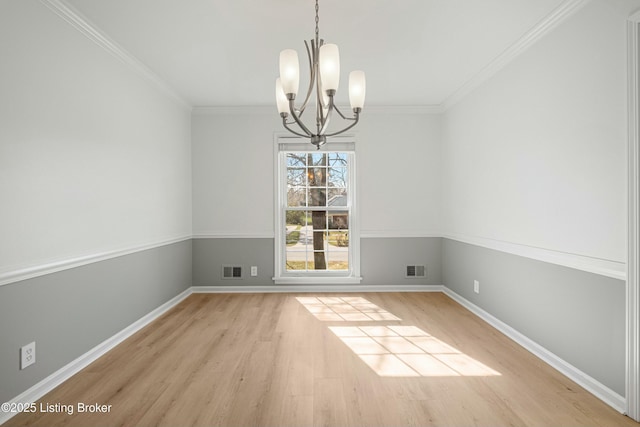 unfurnished dining area featuring crown molding, a notable chandelier, wood finished floors, and visible vents