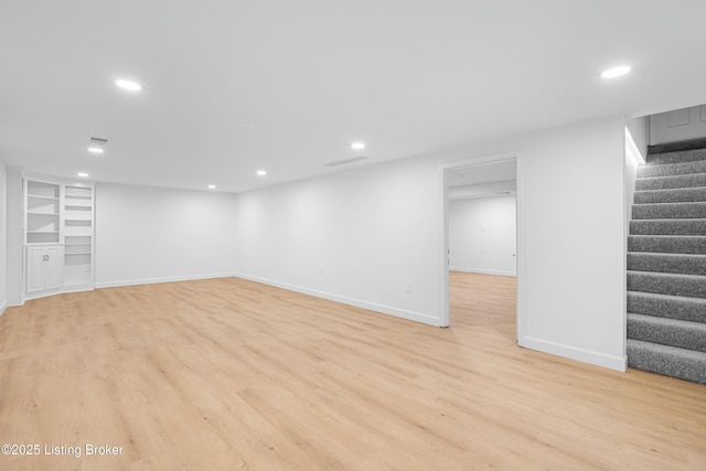 finished below grade area with stairway, recessed lighting, and light wood-style floors