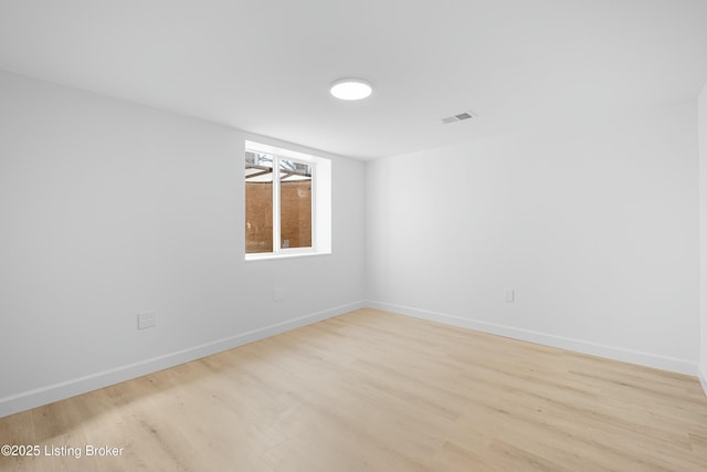 empty room featuring visible vents, baseboards, and light wood-style floors