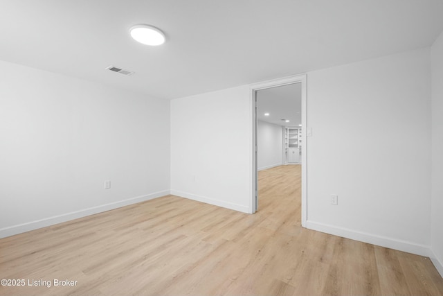 unfurnished room with visible vents, light wood-style flooring, and baseboards