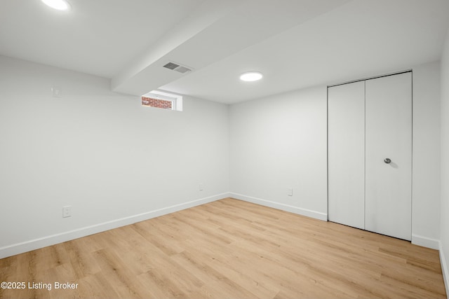 unfurnished bedroom with wood finished floors, visible vents, a closet, and baseboards