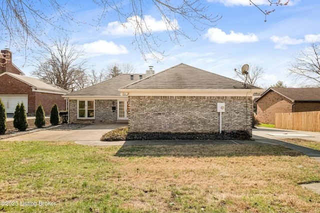 back of house featuring fence, roof with shingles, a chimney, a lawn, and brick siding