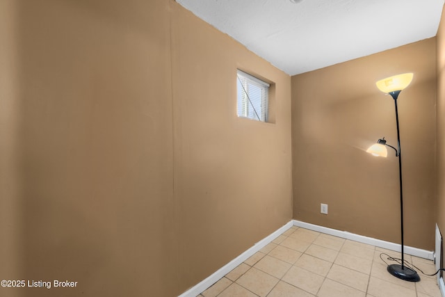 empty room with light tile patterned floors and baseboards