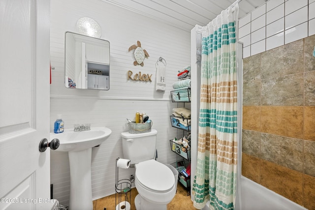 full bath with a sink, shower / bathtub combination with curtain, and toilet