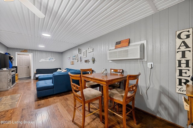 dining room with hardwood / wood-style flooring and a wall mounted air conditioner