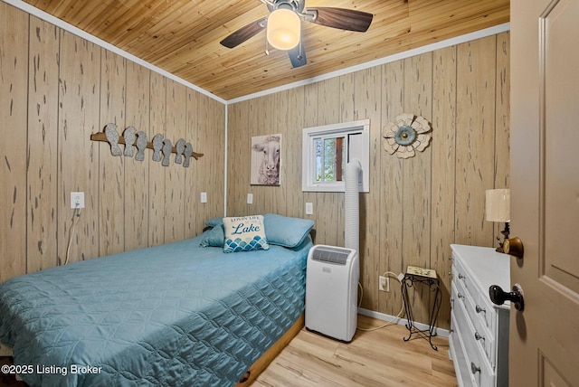 bedroom featuring baseboards, light wood finished floors, ceiling fan, wood ceiling, and wood walls