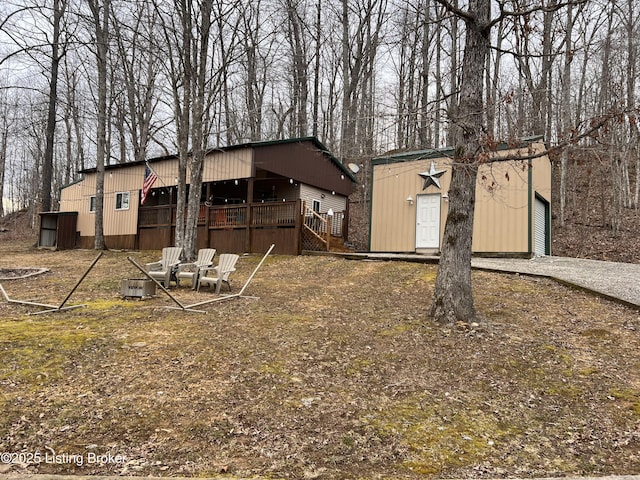 rear view of property featuring a garage and an outdoor structure