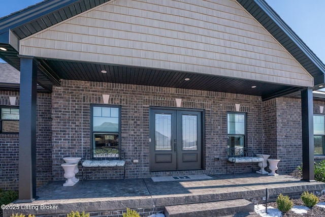 entrance to property featuring french doors and brick siding