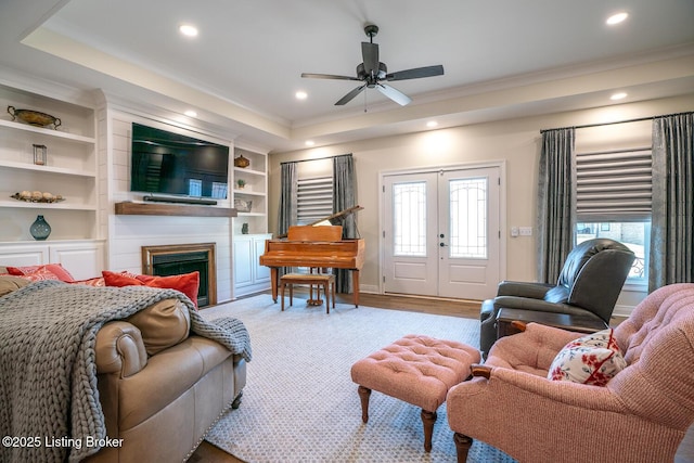 living area with recessed lighting, a fireplace, french doors, and ornamental molding