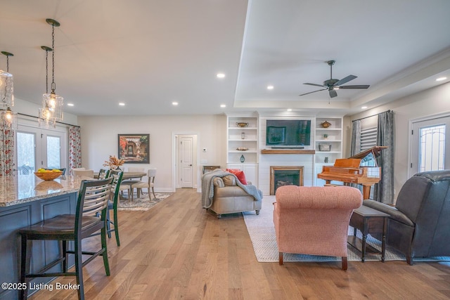 living room with recessed lighting, a large fireplace, light wood-style floors, and plenty of natural light