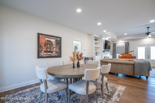 dining room with a raised ceiling, dark wood finished floors, recessed lighting, french doors, and baseboards