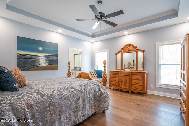 bedroom with baseboards, recessed lighting, hardwood / wood-style flooring, a raised ceiling, and a ceiling fan