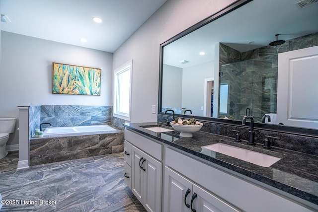 full bathroom featuring toilet, a shower stall, a bath, and a sink