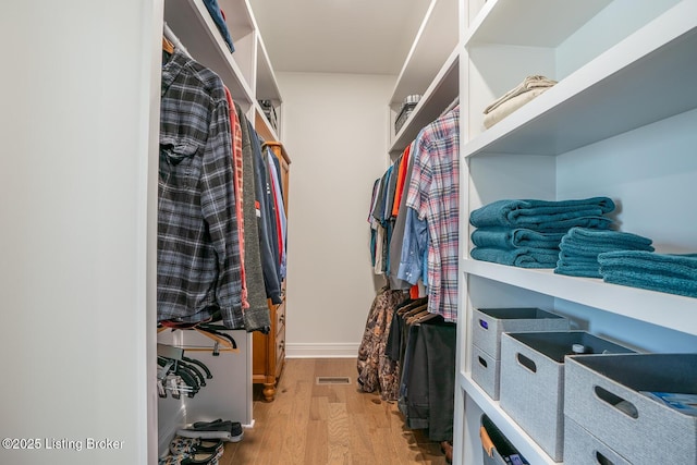 walk in closet with visible vents and wood finished floors