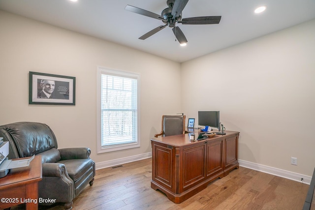 home office featuring light wood-style flooring, a ceiling fan, and baseboards