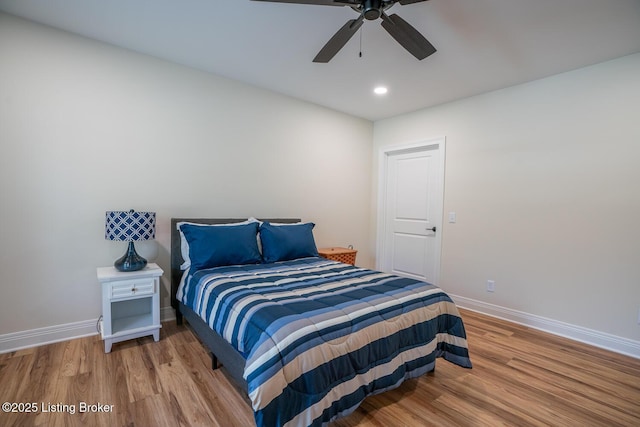 bedroom with ceiling fan, baseboards, and wood finished floors