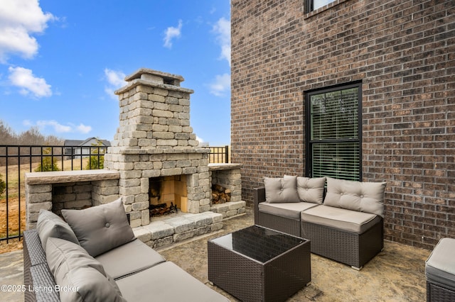 view of patio / terrace with an outdoor living space with a fireplace and fence