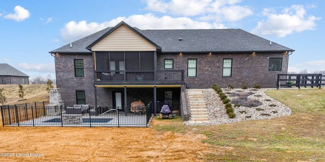 back of property with a patio, fence, stairway, a sunroom, and brick siding