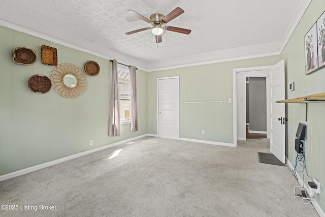 unfurnished living room featuring a textured ceiling, crown molding, a ceiling fan, and carpet floors