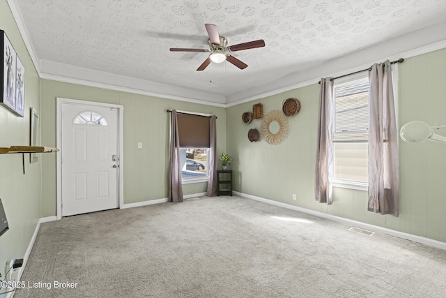 interior space featuring a wealth of natural light, visible vents, carpet floors, and a textured ceiling