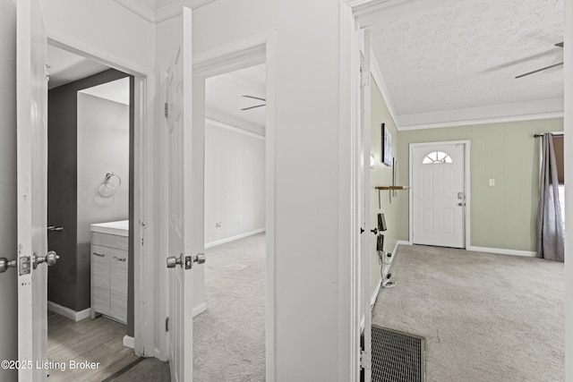 foyer featuring baseboards, carpet, visible vents, and a textured ceiling