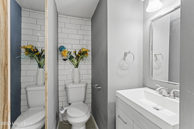 bathroom with tile walls, toilet, and vanity