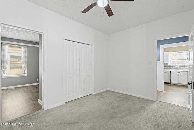 unfurnished bedroom with a sink, baseboards, and light carpet