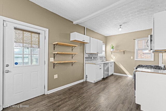 kitchen featuring white microwave, white cabinetry, stainless steel dishwasher, and open shelves