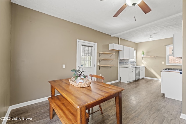 dining room featuring baseboards, a textured ceiling, wood finished floors, and a ceiling fan