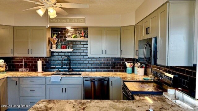 kitchen featuring a sink, light stone counters, backsplash, and black appliances