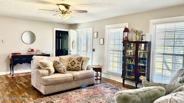 living room featuring a healthy amount of sunlight, a textured ceiling, ceiling fan, and wood finished floors