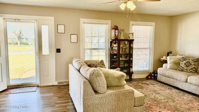 living room with ceiling fan and dark wood-style flooring