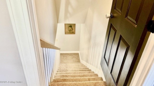 stairway featuring carpet and baseboards