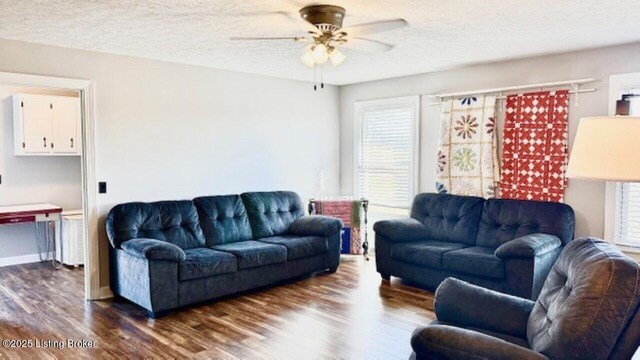 living area featuring dark wood-style floors, baseboards, a textured ceiling, and a ceiling fan