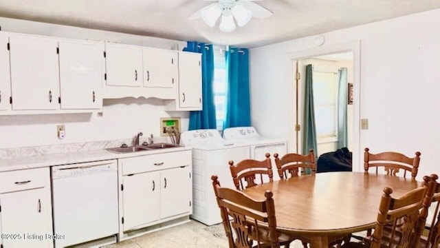 kitchen with a sink, washing machine and dryer, white cabinetry, light countertops, and dishwasher