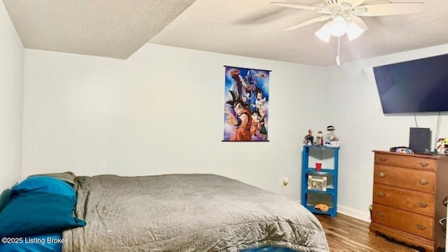 bedroom featuring a ceiling fan, wood finished floors, and a textured ceiling