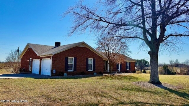 view of side of home with a yard, brick siding, a garage, and driveway