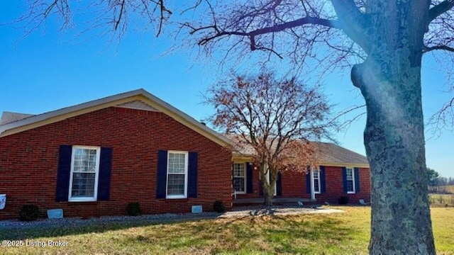 ranch-style home featuring brick siding and a front yard