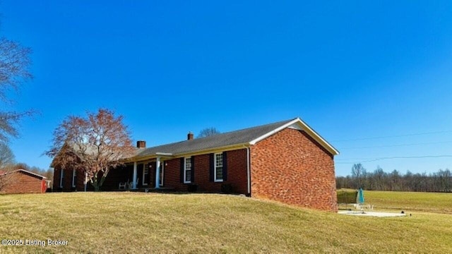 exterior space featuring brick siding and a front lawn