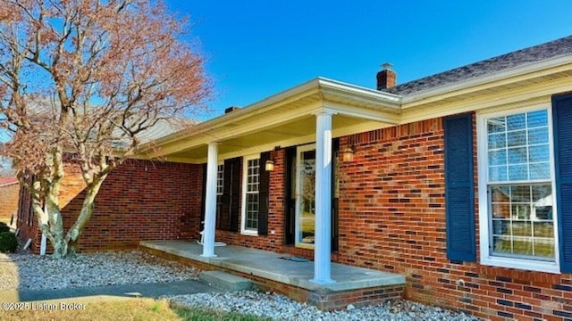 view of side of property with brick siding and a chimney