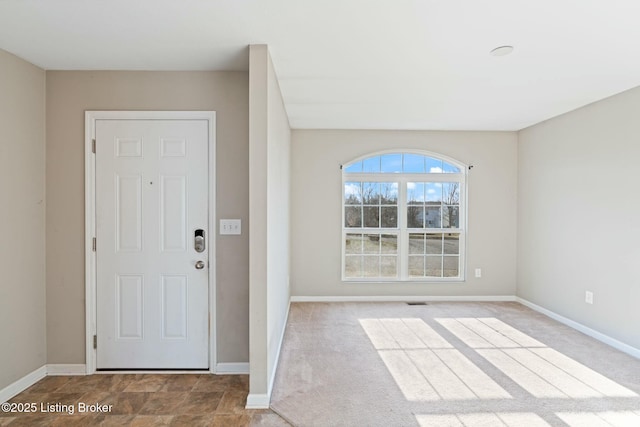 entryway featuring baseboards and carpet flooring