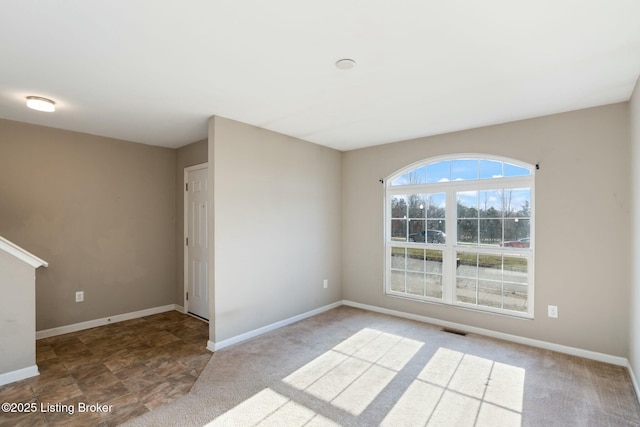 unfurnished room with visible vents and baseboards