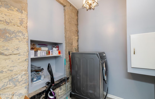 laundry room with a notable chandelier and cabinet space