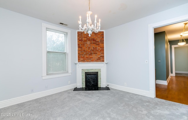 unfurnished living room with visible vents, a fireplace with flush hearth, carpet, an inviting chandelier, and baseboards