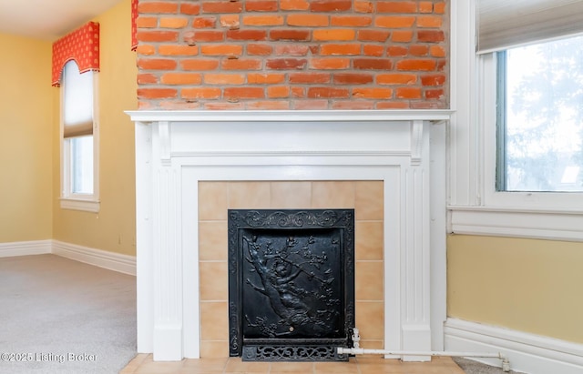 details with baseboards and a tile fireplace