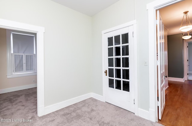 doorway with baseboards and carpet