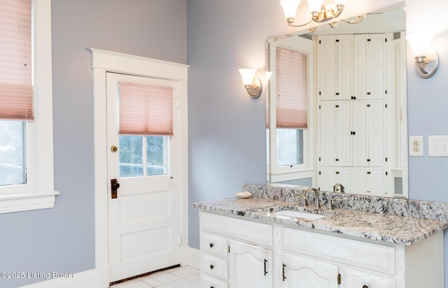 bathroom featuring tile patterned floors, a notable chandelier, and vanity